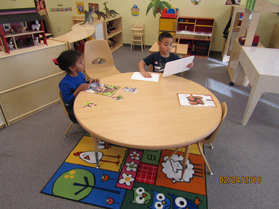 Children working on activities together at a classroom table